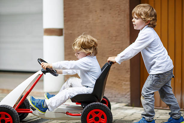 istock Two happy sibling boys playing with toy car 485271974