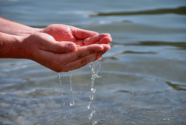 Human hands splashing pure water from river
