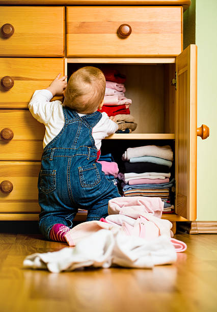 Domestic chores - baby throws out clothes stock photo