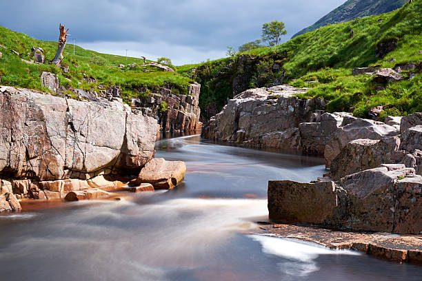 Glen Etive Scenic The River Etive flows down Glen Etive. A long exposure captures the water flowing through one spot where the river narrows. etive river photos stock pictures, royalty-free photos & images
