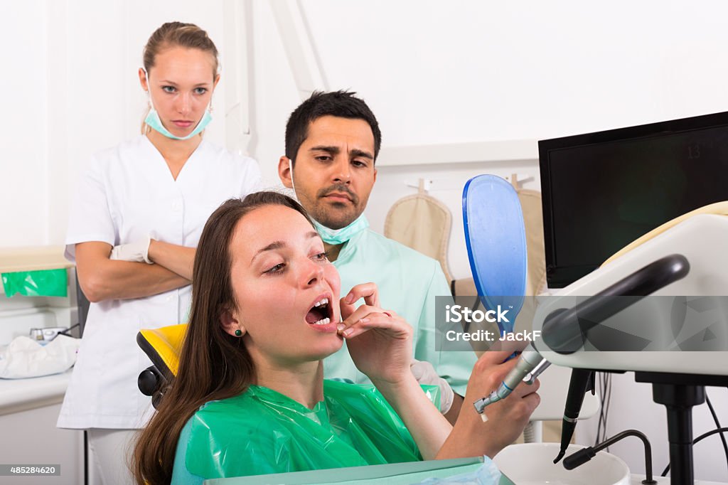 Patient observing her teeth Female patient with problems visiting dentist in the dental clinic Dental Assistant Stock Photo