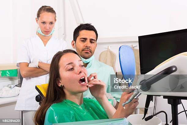 Patient Observing Her Teeth Stock Photo - Download Image Now - Dental Assistant, Serious, 20-29 Years