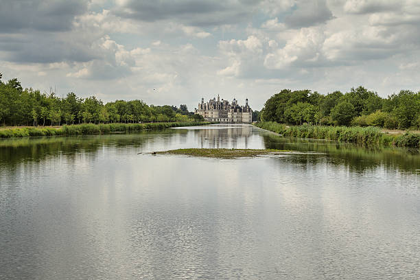 Chambord Castle - Loire - France Chambord, France - August 18, 2015: Panoramic  view of Chambord Castle from the river. Built as a hunting lodge for King Francois I, between 1519 and 1539, this castle is the largest and most frequented of the Loire Valley. blois stock pictures, royalty-free photos & images