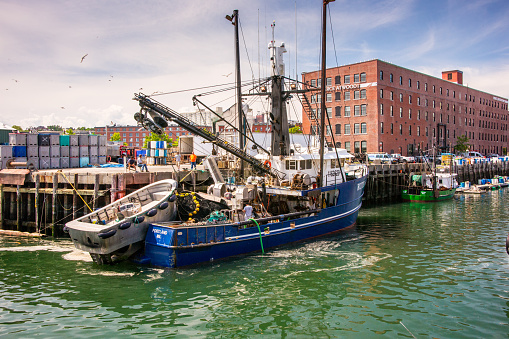 Portland, ME, USA - August 10, 2015: A fishing boat prepares to go to sea in search of herring at Portland Maine's harbor.