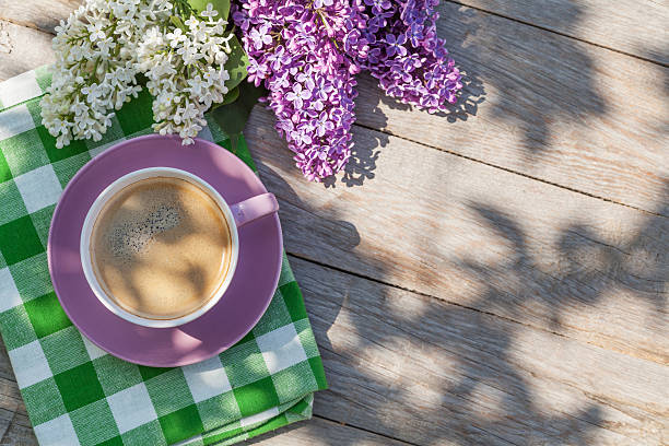 istock Coffee cup and colorful lilac flowers on garden table 485289326