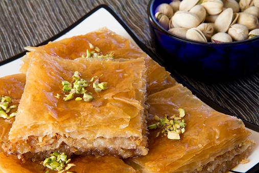 Baklava on a Plate with a Bowl of Pistachios