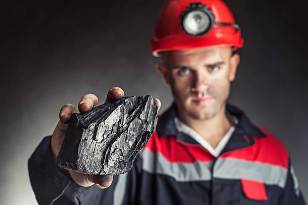 istock miner showing lump of coal 485290047