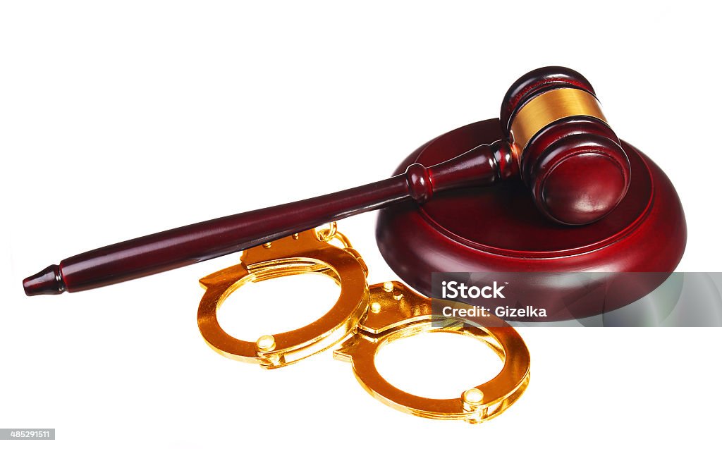 Gold Handcuffs and Judge Gavel isolated Gold Handcuffs and Judge Gavel isolated on white background Criminal Stock Photo