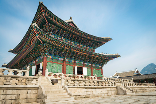 The ornately painted eaves and traditional wooden screens of Geunjeongjeon, Throne Hall of the Joseon Dynasty kings, overlooking the stone courtyard of Gyeongbokgung palace in the historic heart of Seoul, South Korea. ProPhoto RGB profile for maximum color fidelity and gamut.