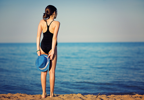 Young girl is looking in the sea.
