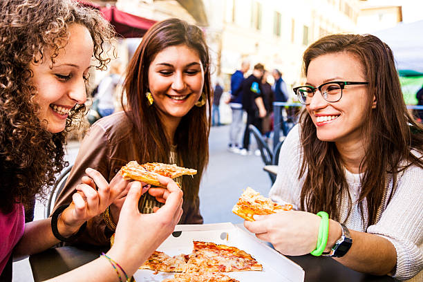 istock Friends eating Pizza on the streets 485310335