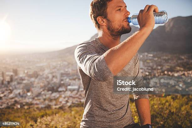 Young Man Taking A Break After Morning Run Stock Photo - Download Image Now - Men, Drinking Water, Drinking