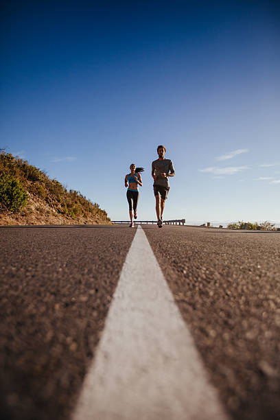 istock Two young people jogging on the road 485311432