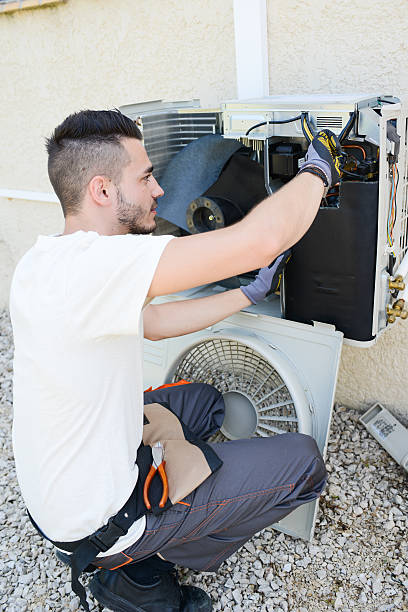 istock handsome young man electrician installing air conditioning in client house 485312522