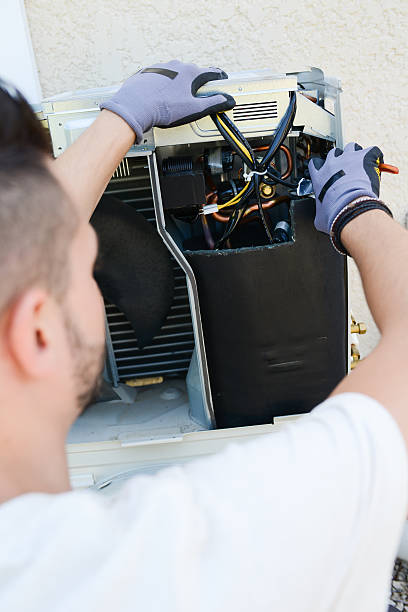 istock handsome young man electrician installing air conditioning in client house 485312646