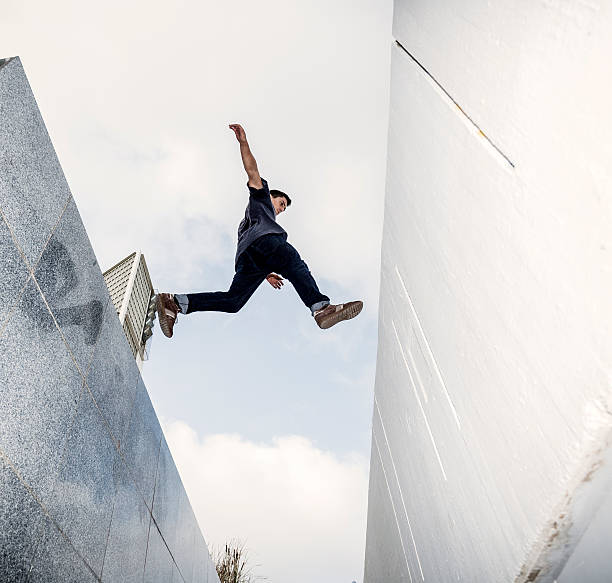 junger mann üben parkour- in der stadt - le parkour stock-fotos und bilder