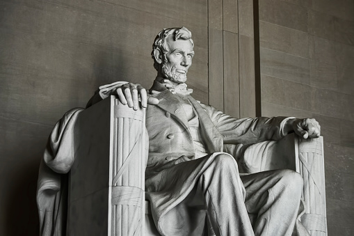 Detail of the marble statue of Abraham Lincoln within the Lincoln Memorial National Monument in Washington DC.