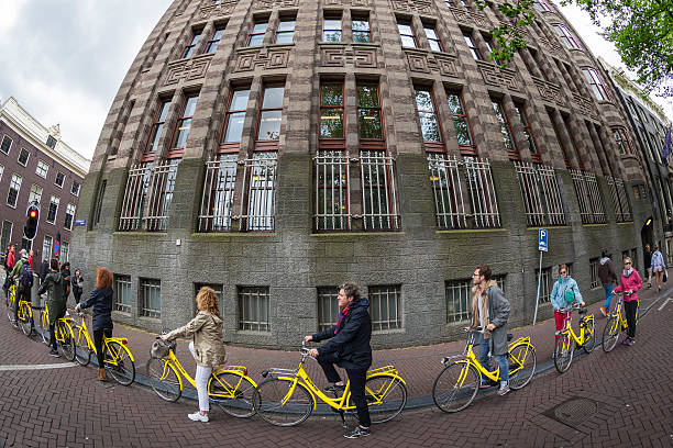 Amsterdam, Netherlands - July 28, 2015: Group of people bicycling in Amsterdam,Netherlands.Bicycling is a very popular mode of travel in the European city of Amsterdam. The people who visit city can rent bikes and have a city tour with bikes.