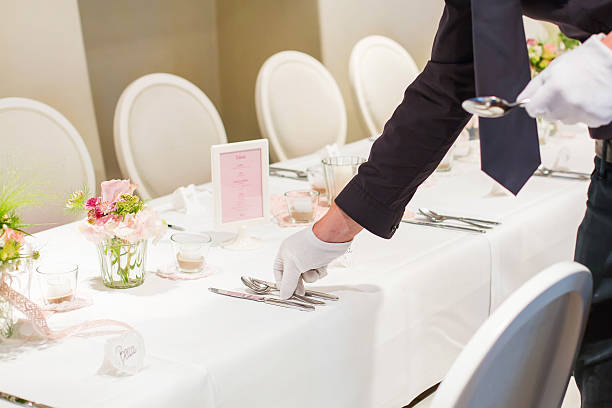 istock Man covering table with cutlery for wedding 485325668