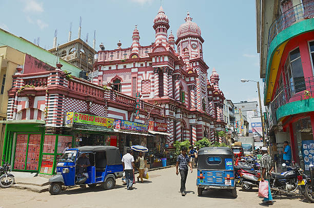 People walk by the street in downtown Colombo, Sri Lanka. Colombo, Sri Lanka - May 17, 2011: Unidentified people walk by the street with colonial architecture building at the background in downtown Colombo, Sri Lanka. sri lanka business stock pictures, royalty-free photos & images