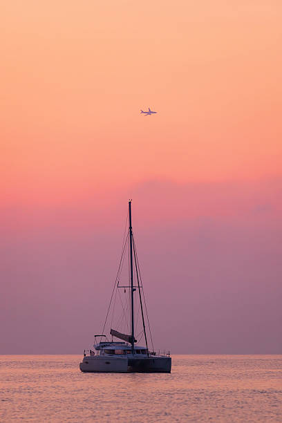 Sailing catamaran on a background of beautiful sunrise stock photo