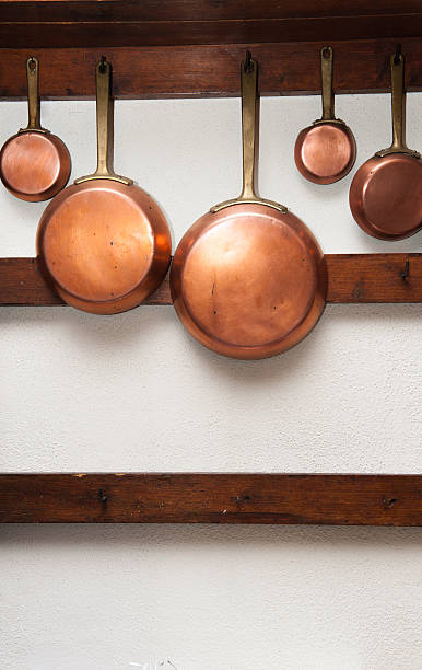 istock Vintage copper pans hung on wooden shelf 485331016
