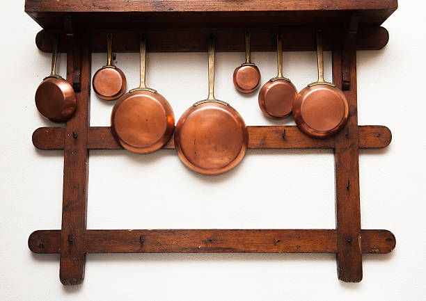 istock Vintage copper pans hung on wooden shelf 485331018
