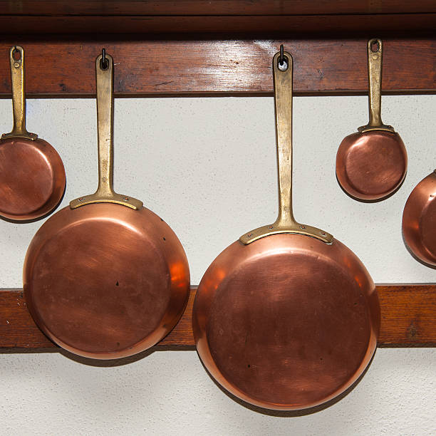 istock Vintage copper pans hung on wooden shelf 485333596
