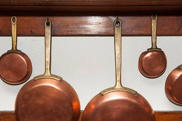 istock Vintage copper pans hung on wooden shelf 485333598