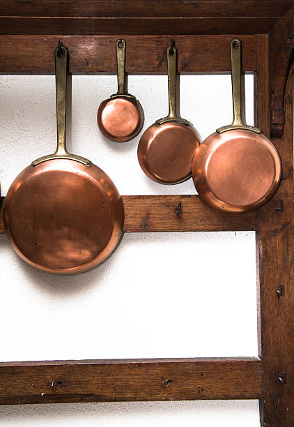 istock Vintage copper pans hung on wooden shelf 485333602