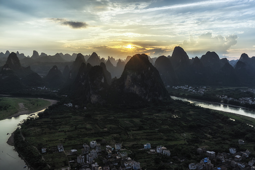 The view of sunset from laozhai shan in near xingping, guangxi, china. Taken during hot summer. xingping is near yangshuo. The view of karst mountains and hill tops.