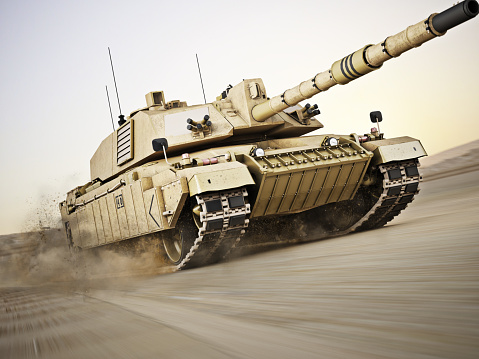 A wide-angle front view of a Japanese self-defense force military tank driving down a dirt road lined with trees with a dramatic sky.