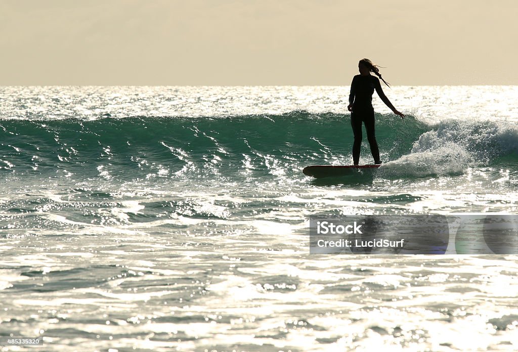 Surfer girl rides wave A young woman surfing on waves, New Zealand 2015 Stock Photo