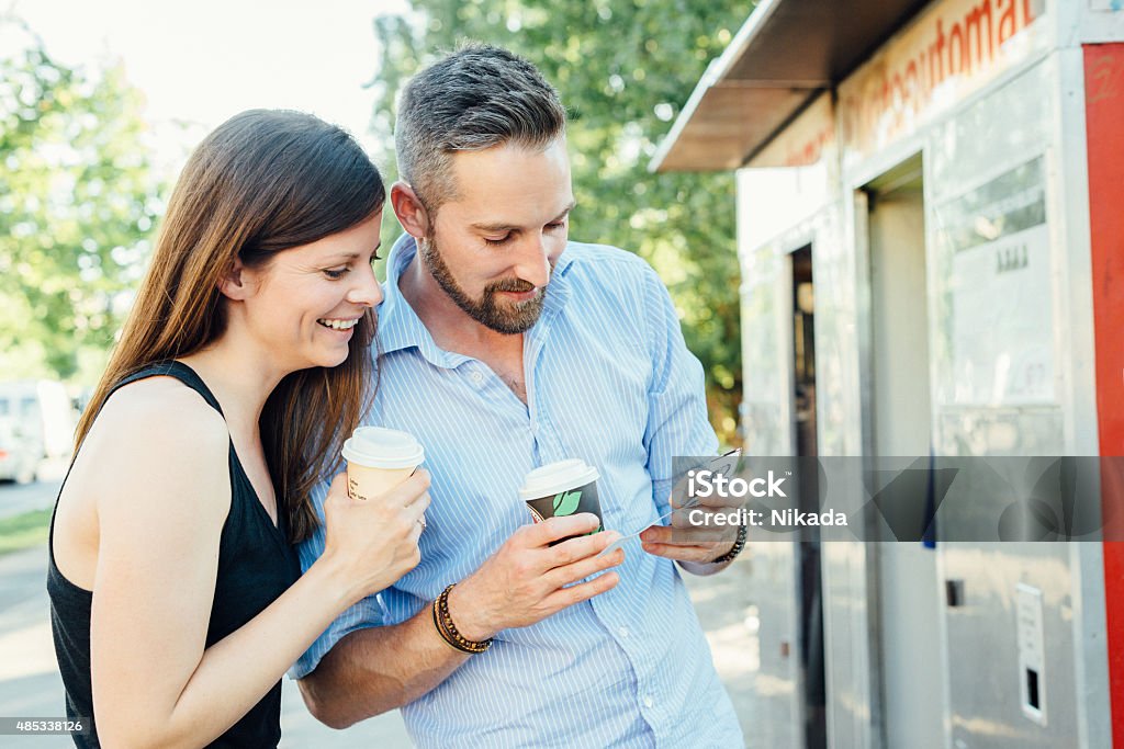 young happy couple look at selfie picture prints young happy couple with coffee look at selfie picture prints 2015 Stock Photo