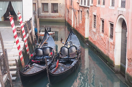 Two gondola in Venice near pier in channel