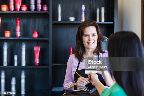 Saleswoman Taking Credit Card From Customer Stock Photo - Download Image Now - Hair Salon, Merchandise, Paying