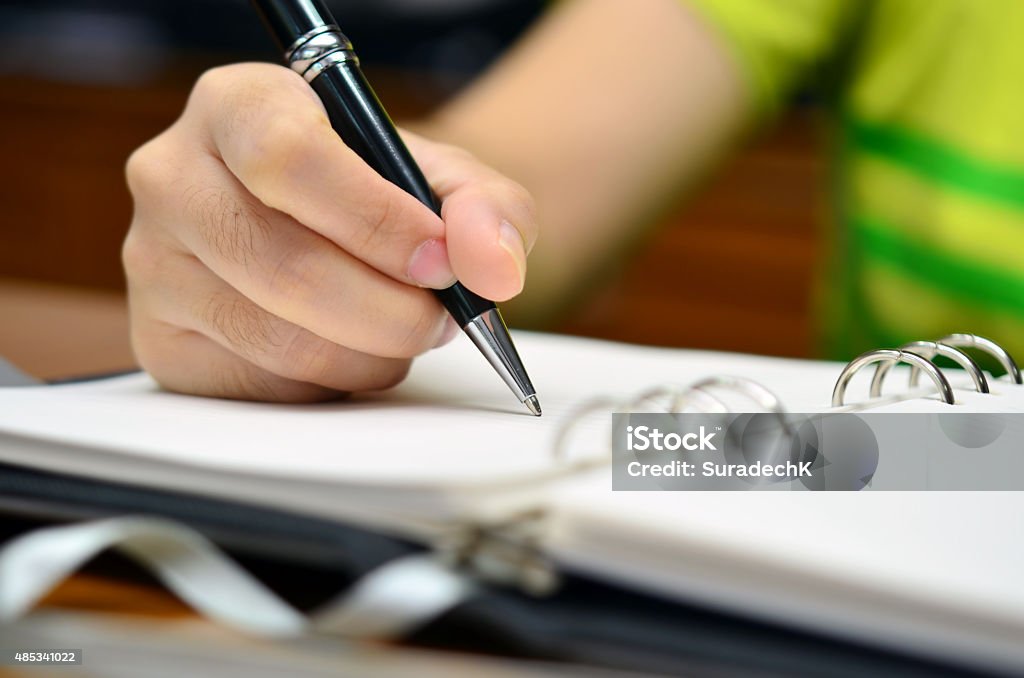 Hand writes on a book with a pen A girl writes on her diary, writing on memo, book 2015 Stock Photo