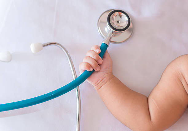 medical instruments stethoscope in hand of newborn baby girl medical instruments stethoscope in hand of newborn baby girl. pediatrician stock pictures, royalty-free photos & images