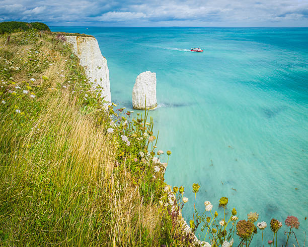 istock Blue ocean boat white cliffs sea stacks Jurassic Coast Dorset 485342614