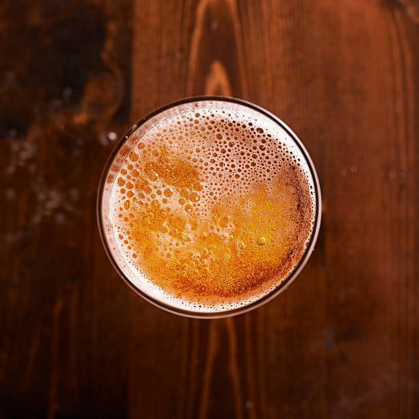 bicchiere di birra in alto verso il basso - amber beer foto e immagini stock