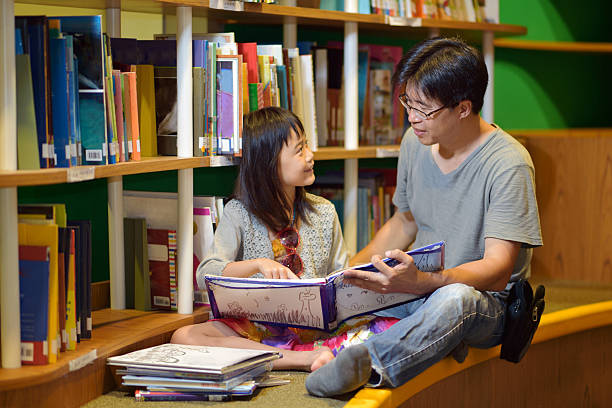 アジアの女の子と父親リーティングのライブラリー - bookstore student chinese ethnicity book ストックフォトと画像