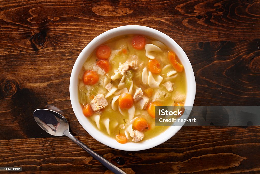 bowl of chicken noodle soup shot top down bowl of chicken noodle soup shot top down on wooden table top Chicken Noodle Soup Stock Photo