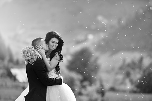 black and white shot of bride and groom embracing, kissing and enjoying their first day of marriage.
