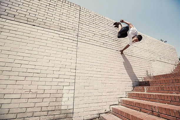 Parkour in the city Young man practicing parkour in the city free running stock pictures, royalty-free photos & images