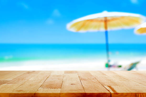 istock Wood table top on blur beach backgroud 485365824