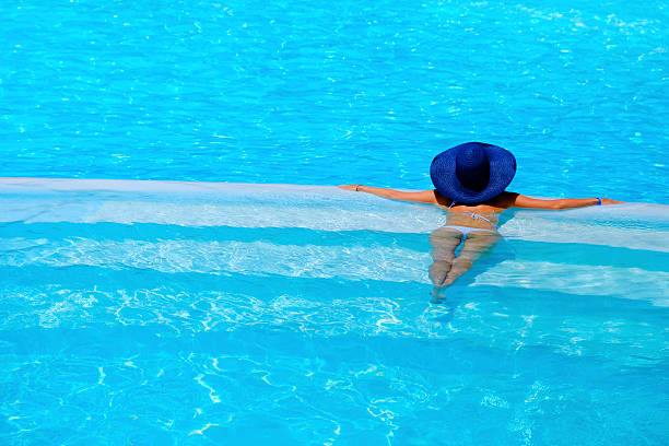 istock woman relaxing at a resort swimming pool 485366120