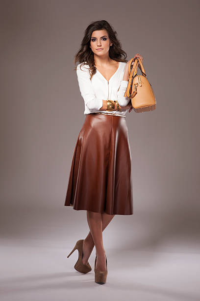 istock Elegant woman holding a brown purse 485367510