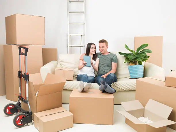 couple on sofa talking about decorations after moving in new house
