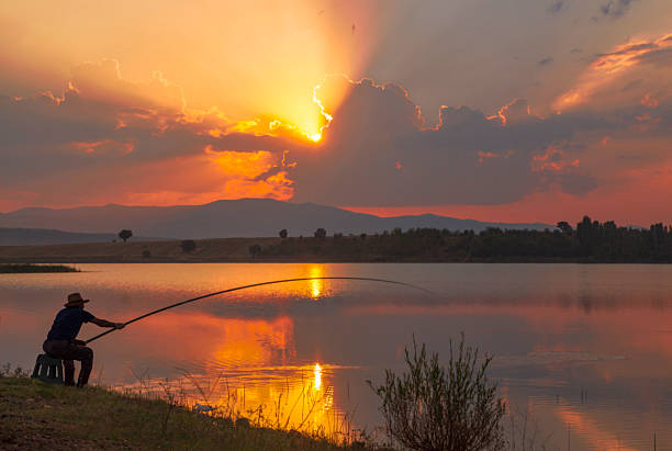 rybak sylwetka na zachód słońca - fishing fishing industry fly fishing river zdjęcia i obrazy z banku zdjęć