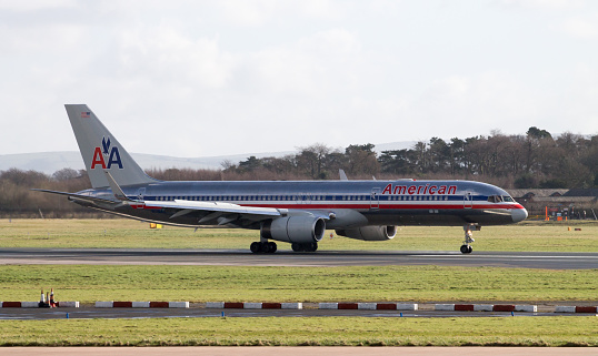 Manchester, United Kingdom - February 16, 2014: American Airlines Boeing 767 plane taxiing after landing on Manchester Airport runway, heat emanating from engines. 14-year old Dutch girl got arrested for sending a bomb threat to the American Airlines, US-based carrier. 